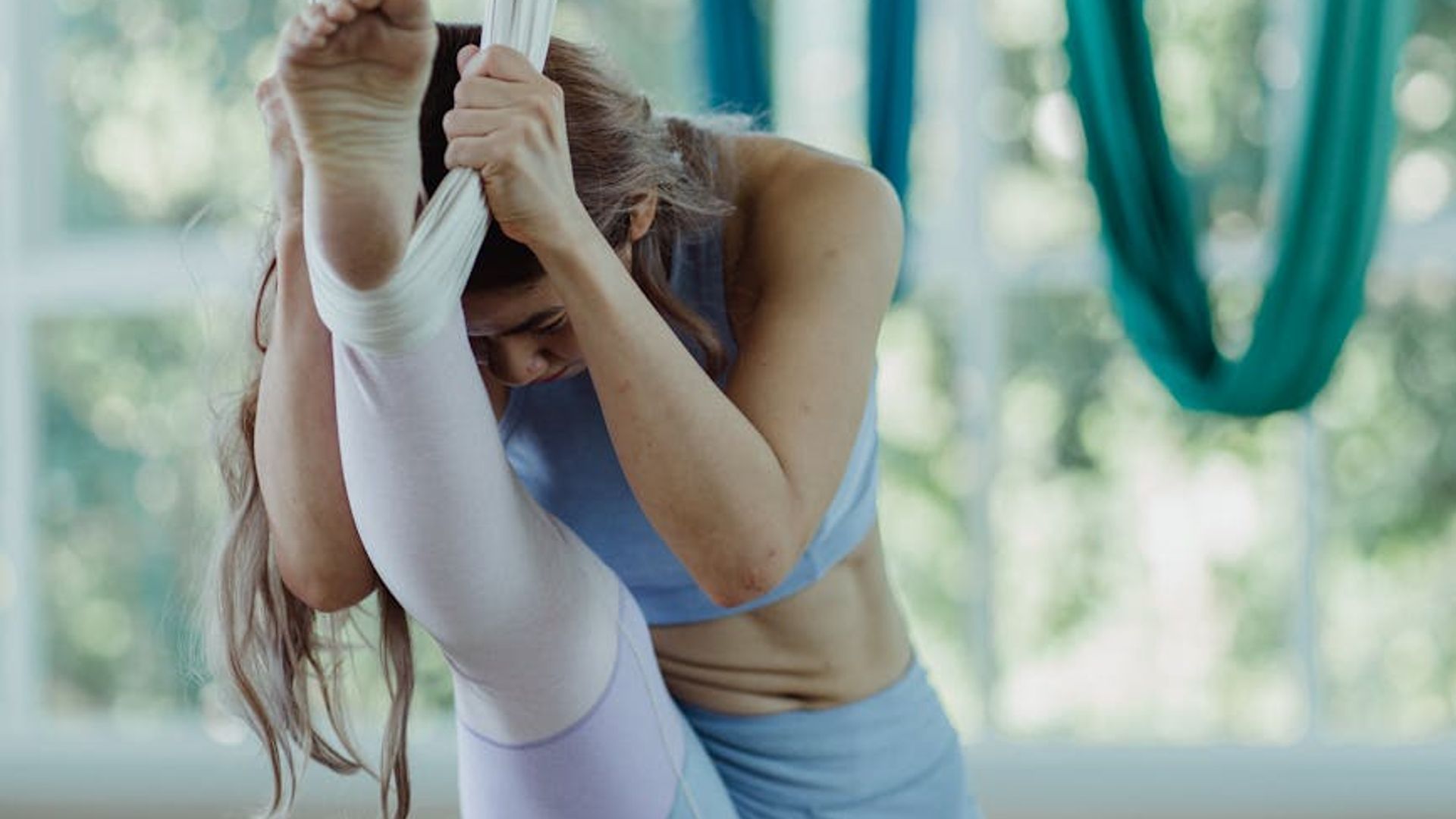 Person performing calm yoga movements in a bright airy studio